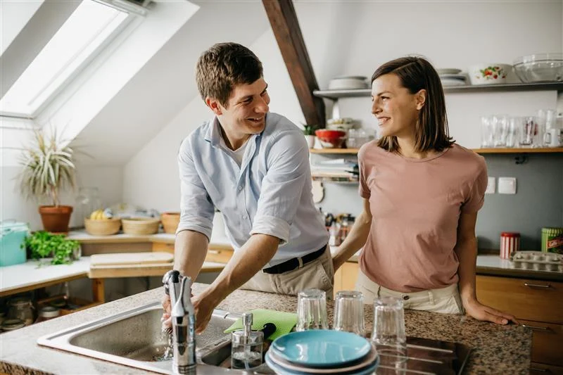 pareja en la cocina fregando los platos