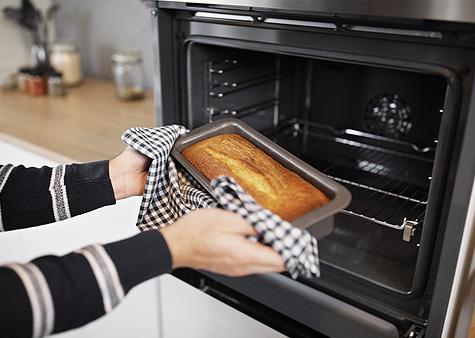 Persona sacando un bizcocho del horno