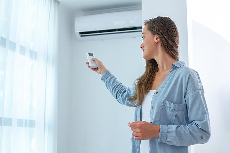 Mujer encendiendo el aire acondicionado