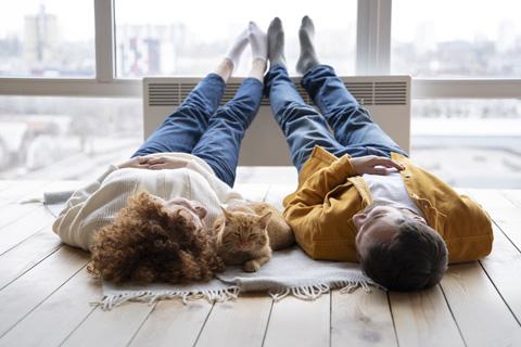 pareja tumbada con los pies en el radiador frente a la ventana